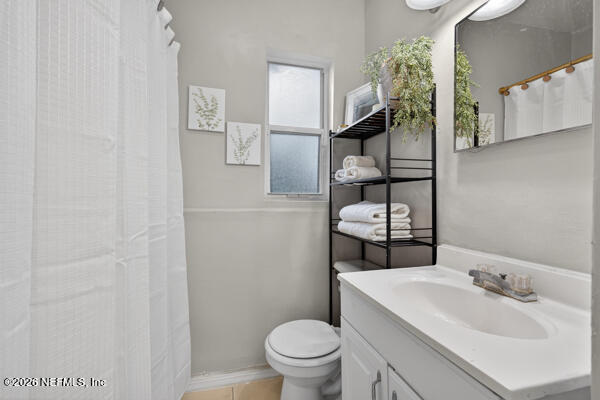 7143 King Arthur Road North Jacksonville, FL 32211 - Photo 14 of 18 a bathroom with a toilet sink and mirror