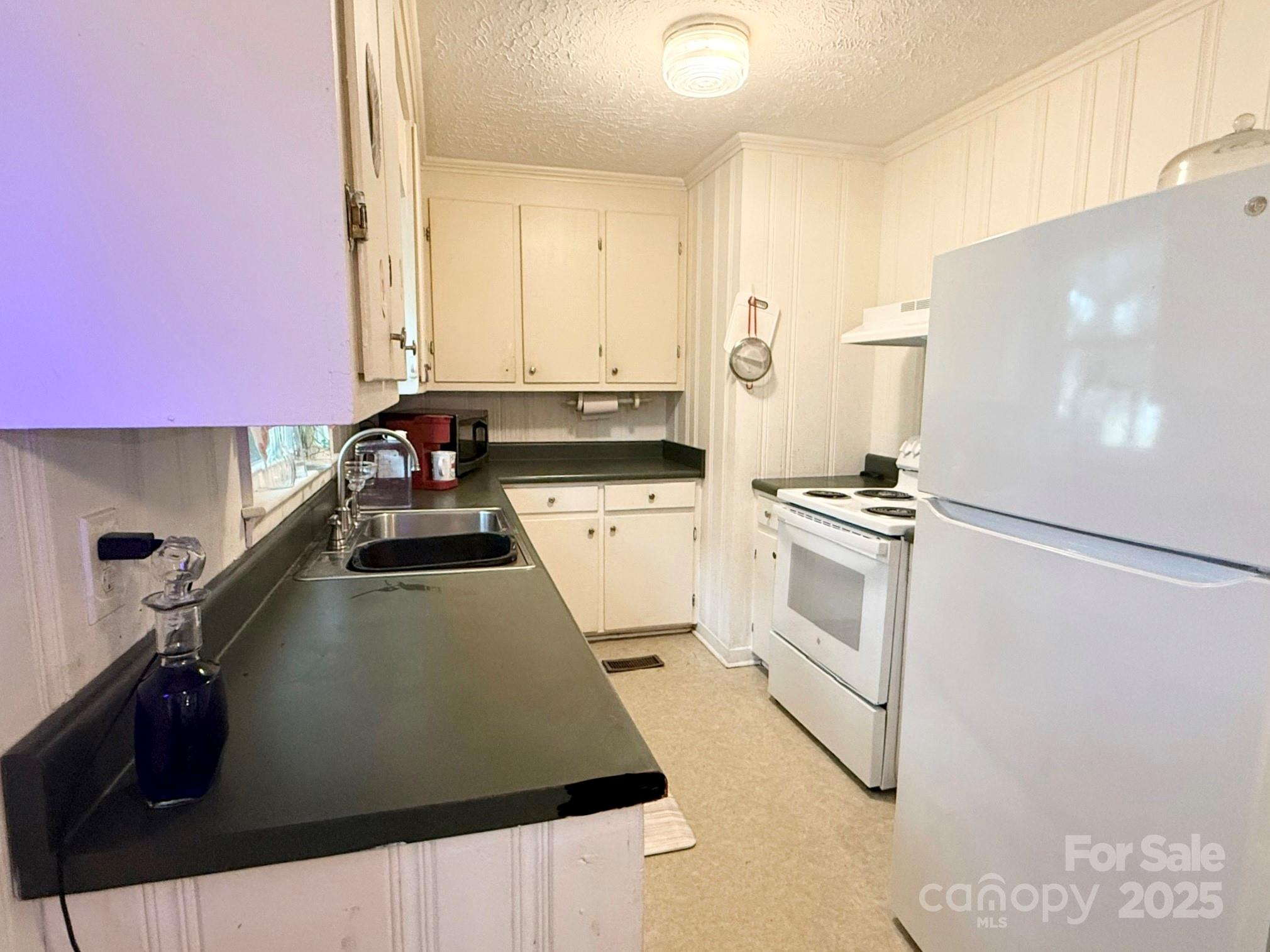 101 Windsor Drive Cheraw, SC 29520 - Photo 9 of 17 a kitchen with a white cabinets and white appliances
