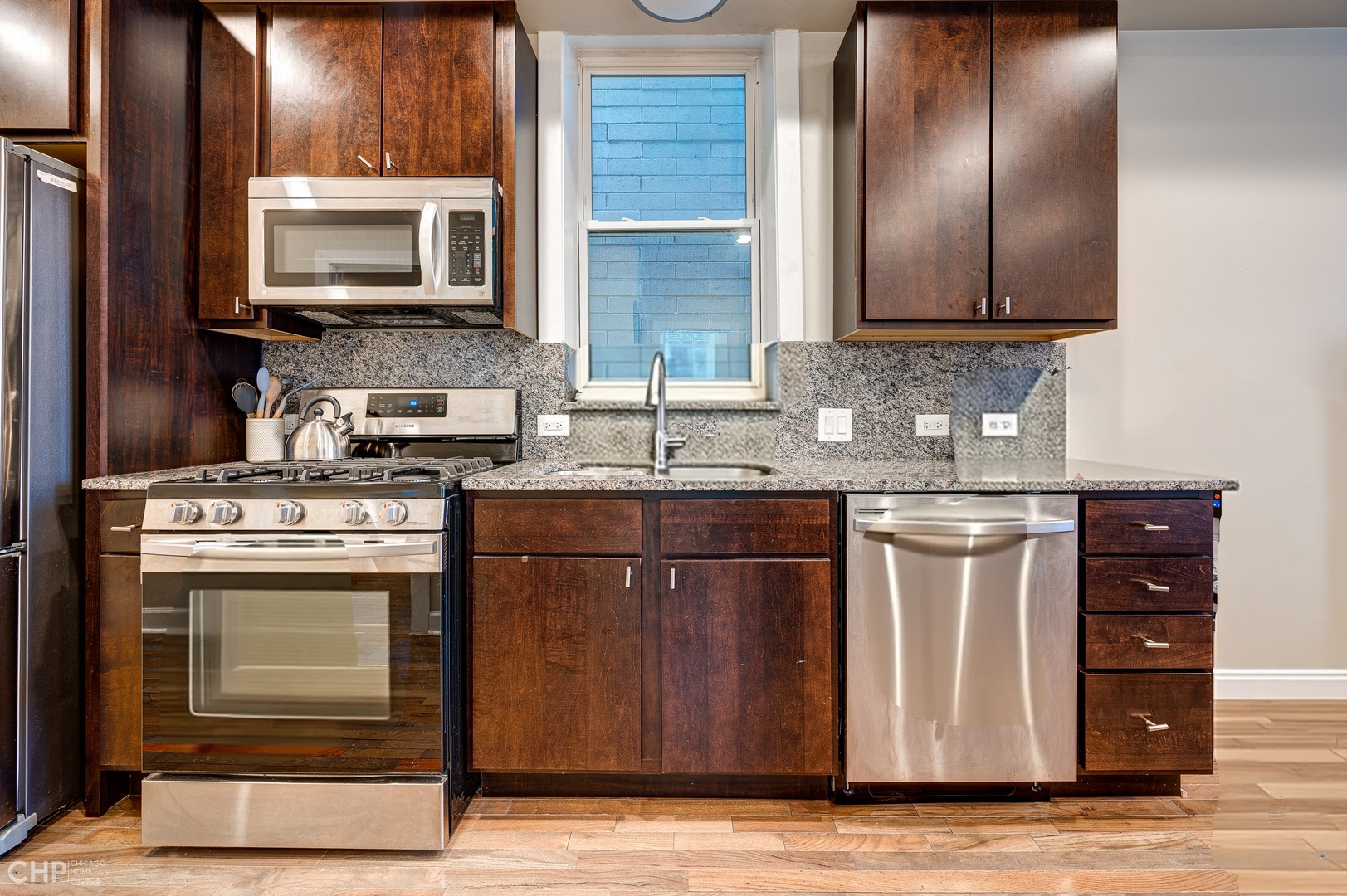1716 South Clinton Street Chicago, IL 60616 - Photo 3 of 18 a kitchen with stainless steel appliances granite countertop a stove a microwave and a sink