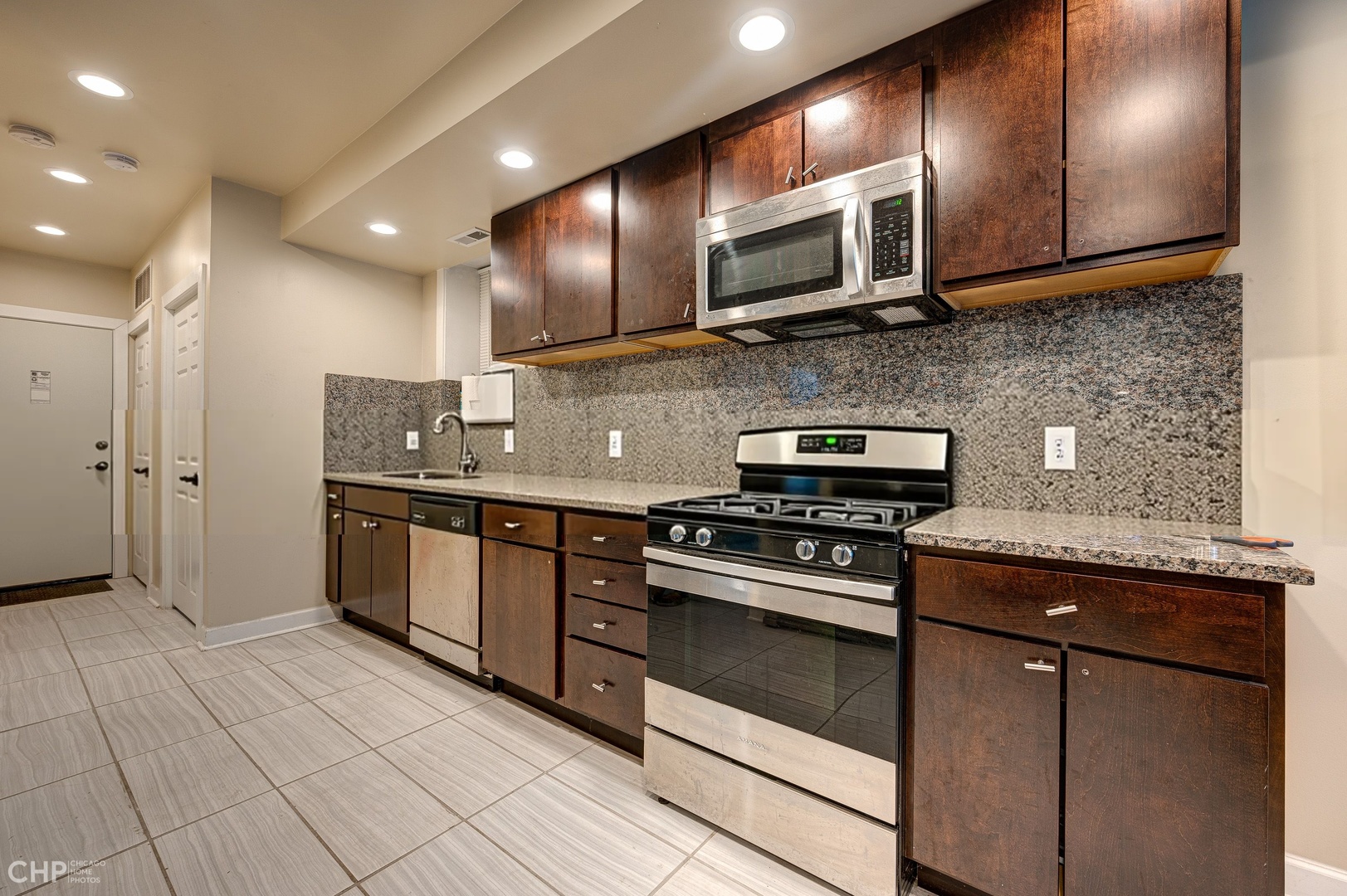 1716 South Clinton Street Chicago, IL 60616 - Photo 8 of 18 a kitchen with stainless steel appliances granite countertop a stove a sink and a microwave