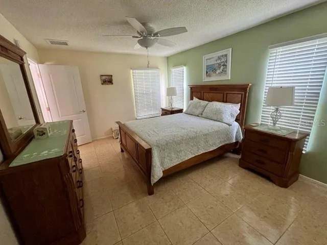 a spacious bedroom with a bed and wooden floor