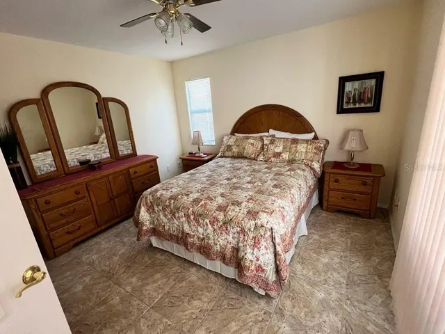 a bedroom with a bed and a dresser with flowerpot