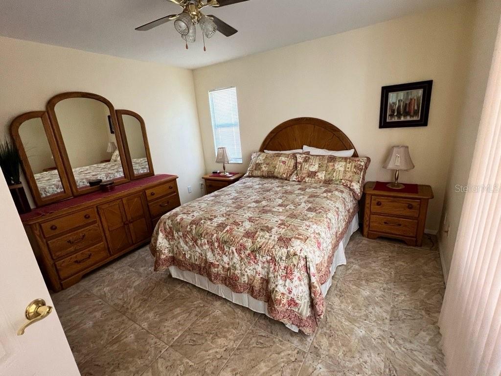 Undisclosed Address Bradenton, FL 34209 - Photo 19 of 38 a bedroom with a bed and a dresser with flowerpot