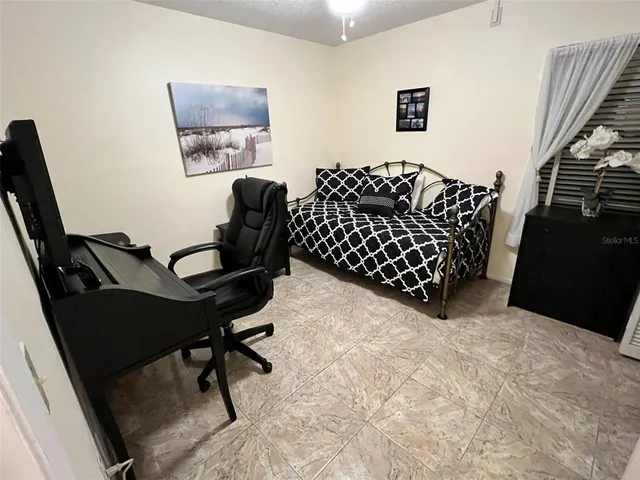 a bed room with a bed window and a chandelier
