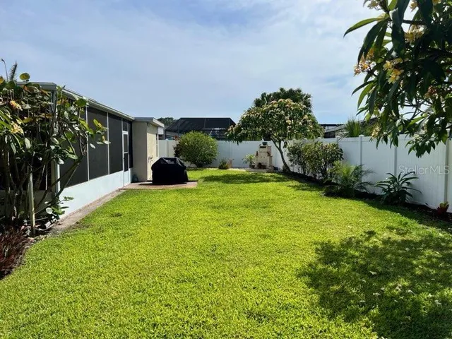 a backyard of a house with table and chairs under an umbrella