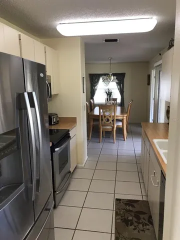 a kitchen with stainless steel appliances granite countertop a stove a refrigerator and a dining table