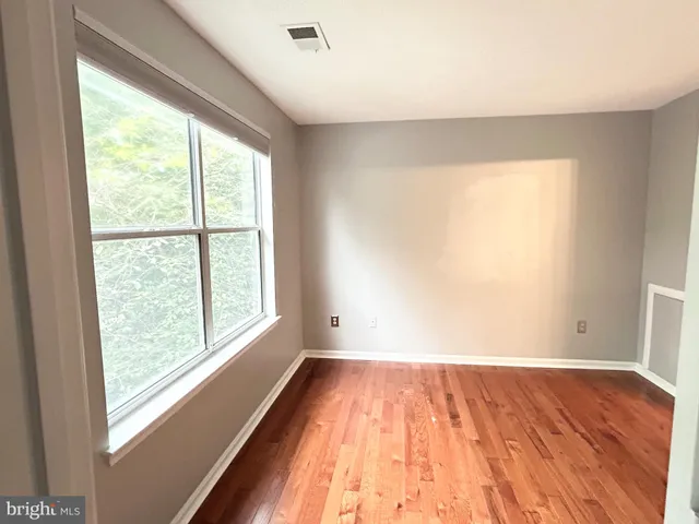 a view of a room with wooden floor and a window