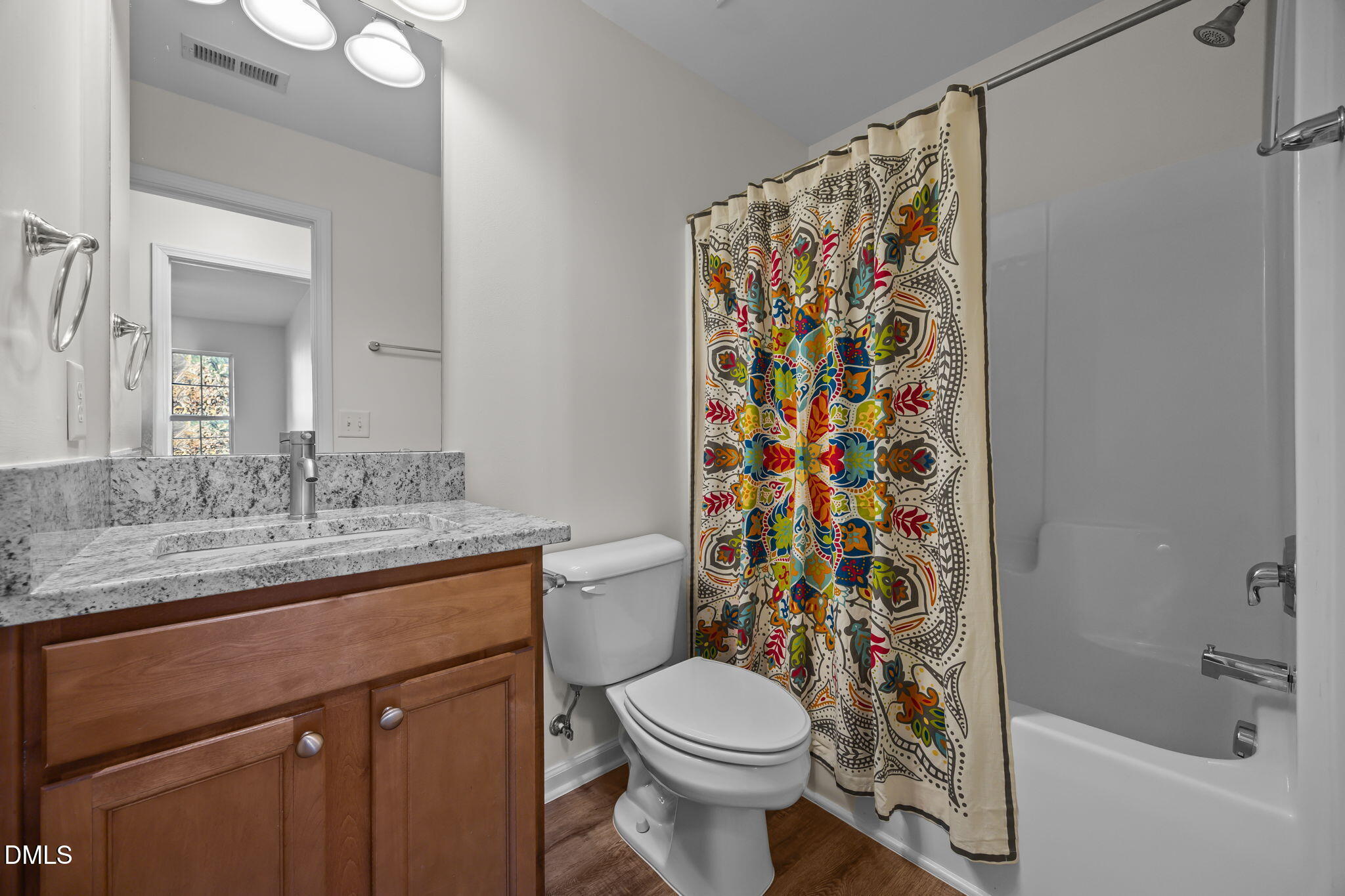 7008 Racine Way Raleigh, NC 27690 - Photo 27 of 36 a bathroom with a granite countertop sink a toilet and shower curtain
