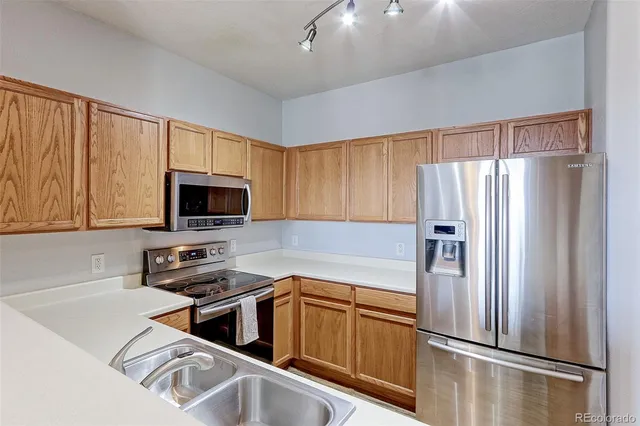 a kitchen with stainless steel appliances a refrigerator sink and microwave