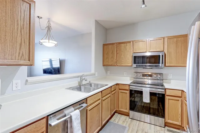 a kitchen with stainless steel appliances a stove sink and microwave