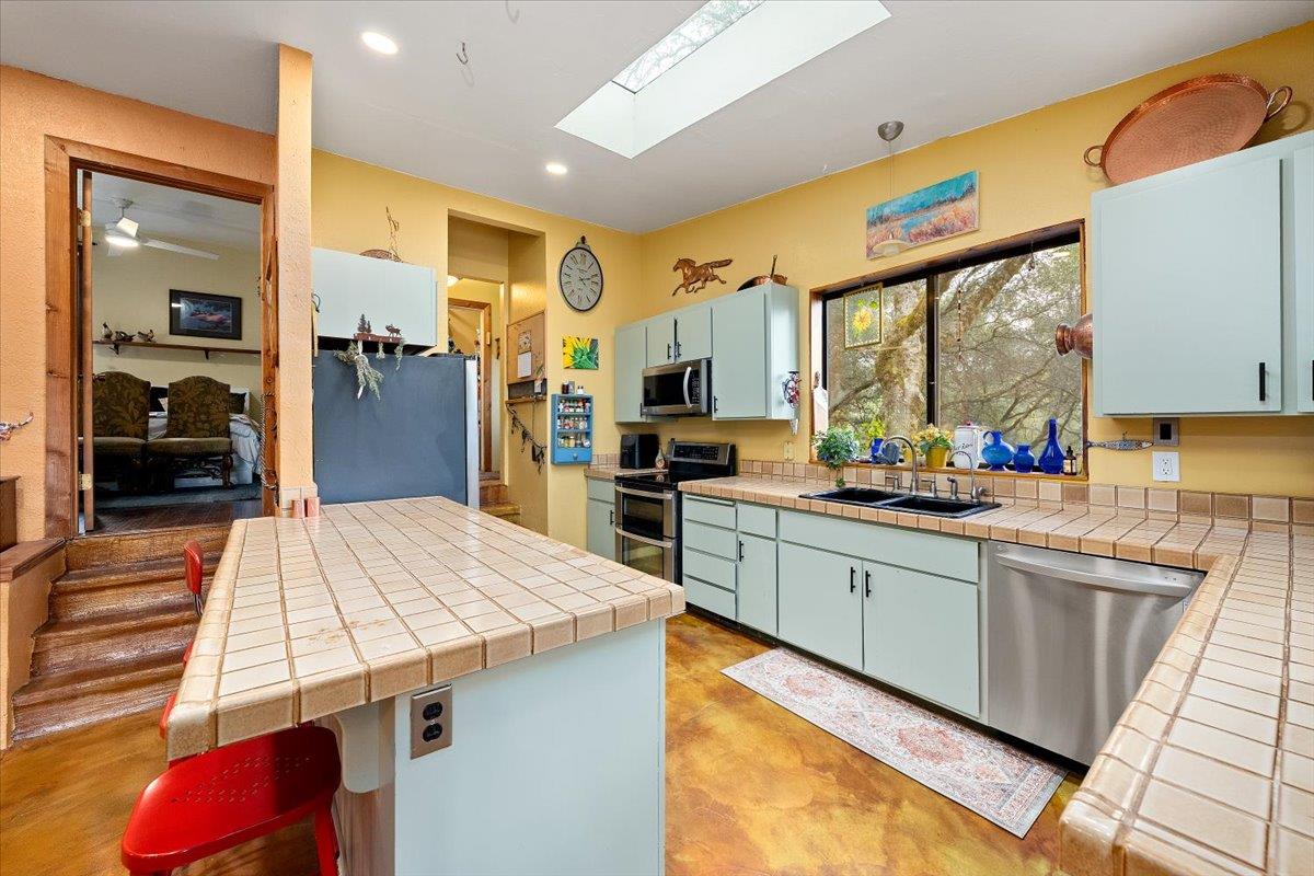 2244 Windmill Court Cool, CA 95614 - Photo 12 of 73 a kitchen with stainless steel appliances kitchen island granite countertop a sink and cabinets