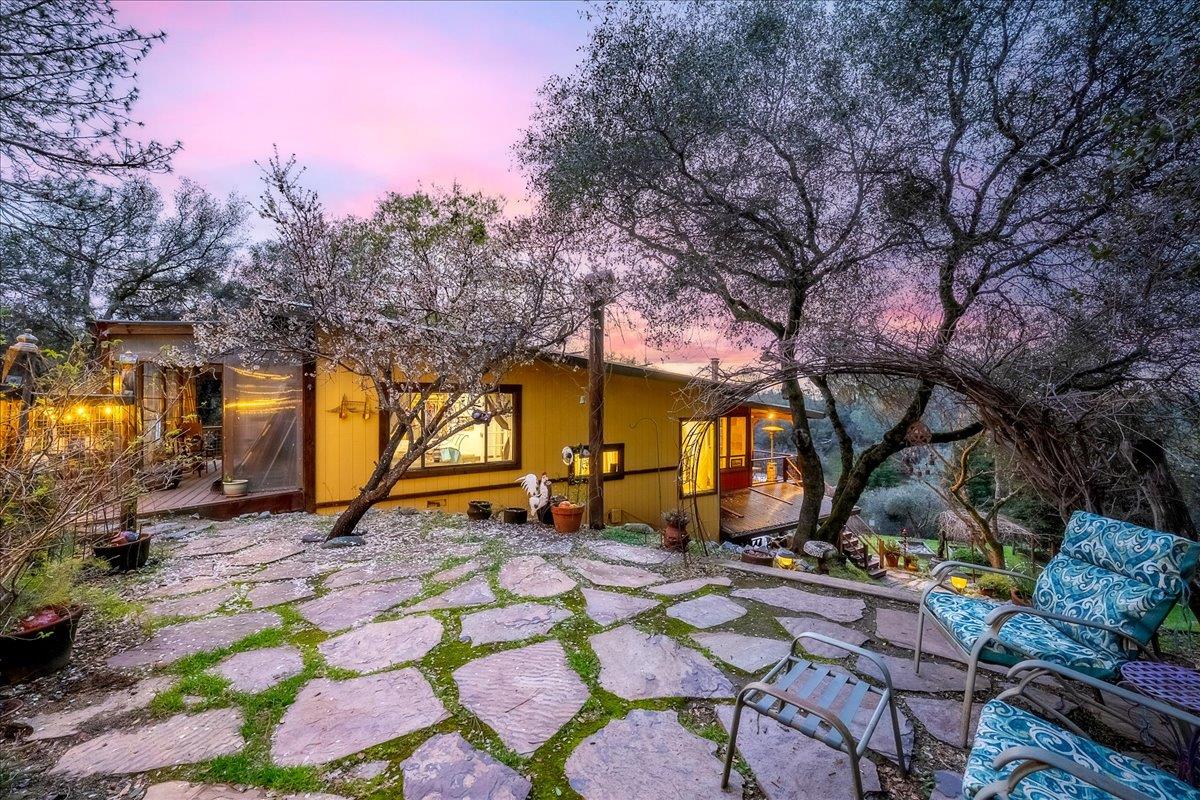 2244 Windmill Court Cool, CA 95614 - Photo 6 of 73 a backyard of a house with barbeque oven table and chairs under an umbrella