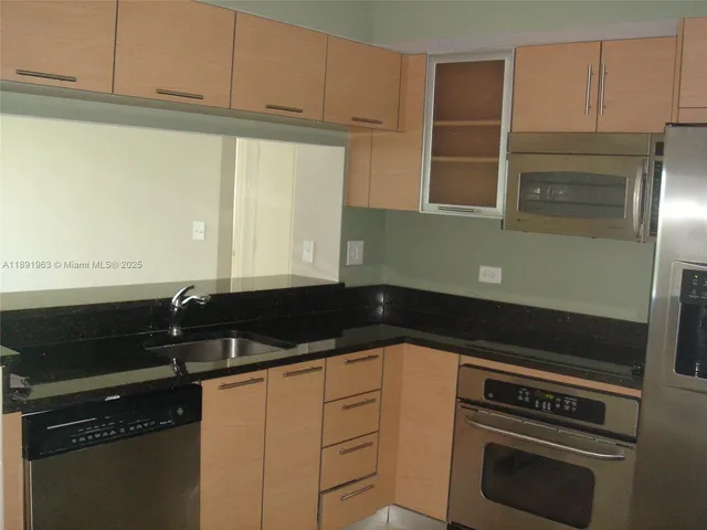a kitchen with granite countertop white cabinets and black appliances