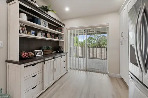 a kitchen with granite countertop white cabinets and black appliances