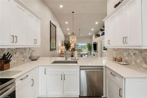 a kitchen with granite countertop a table chairs microwave and sink