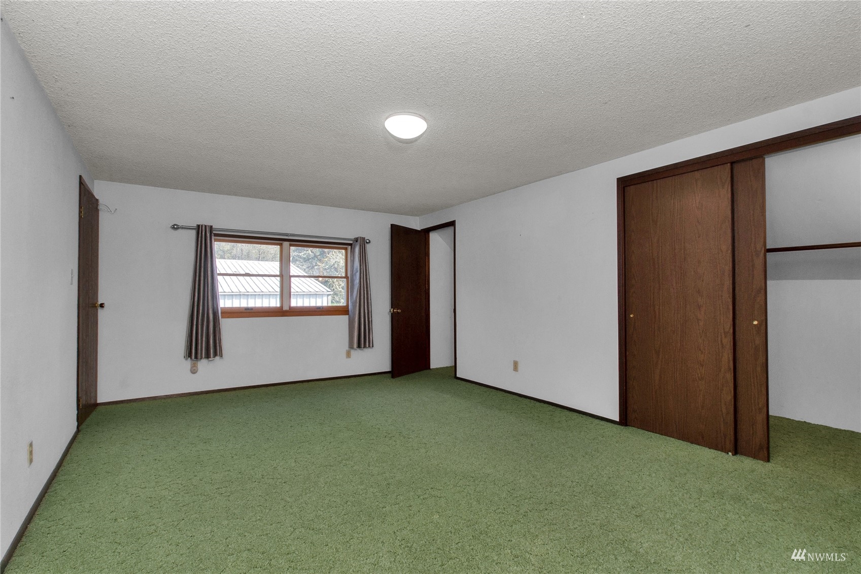 12128 Hunter Loop Road Southwest Rochester, WA 98579 - Photo 16 of 31 an empty room with windows