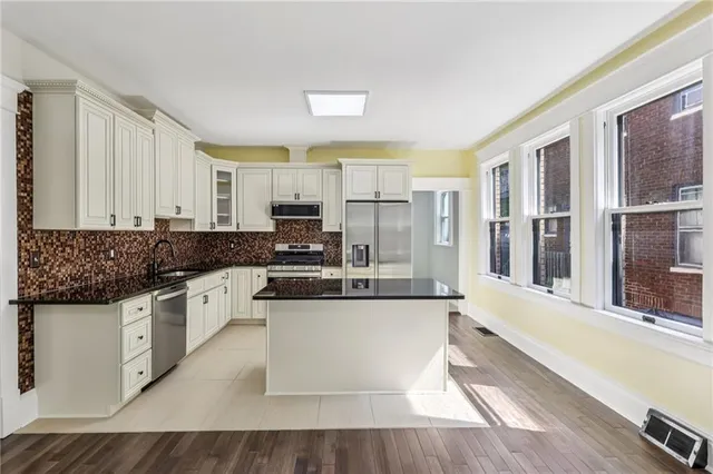 a large kitchen with stainless steel appliances and cabinets