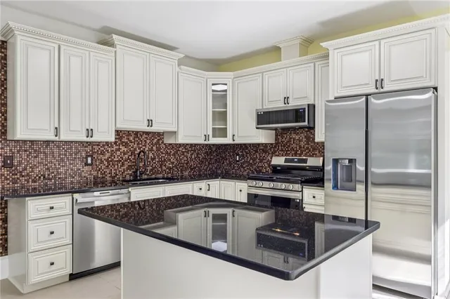 a kitchen with white cabinets and stainless steel appliances