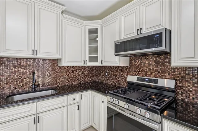 a kitchen with stainless steel appliances a stove and cabinets