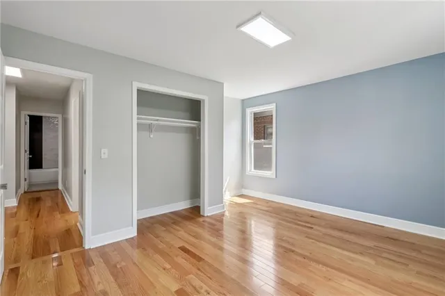 an empty room with wooden floor and closet