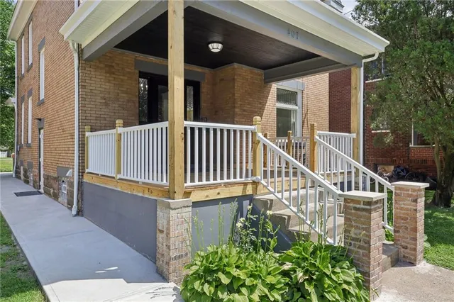 a view of a house with porch and wooden fence