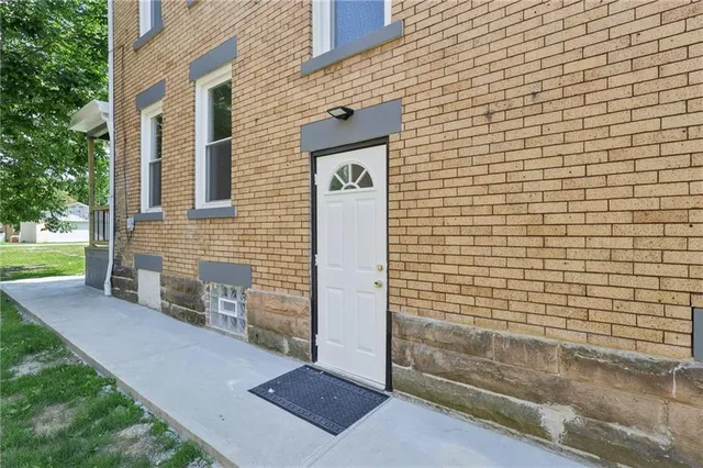 a view of a house with backyard and sitting area