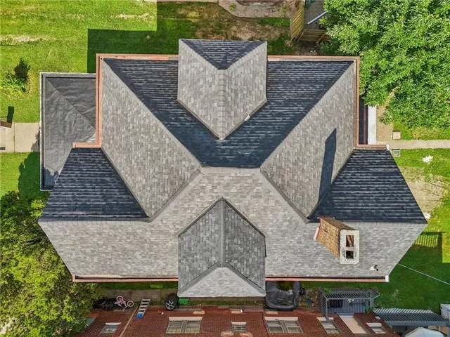 an aerial view of residential houses with outdoor space and trees