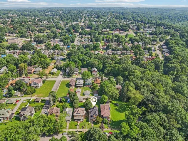 an aerial view of residential houses with outdoor space and trees