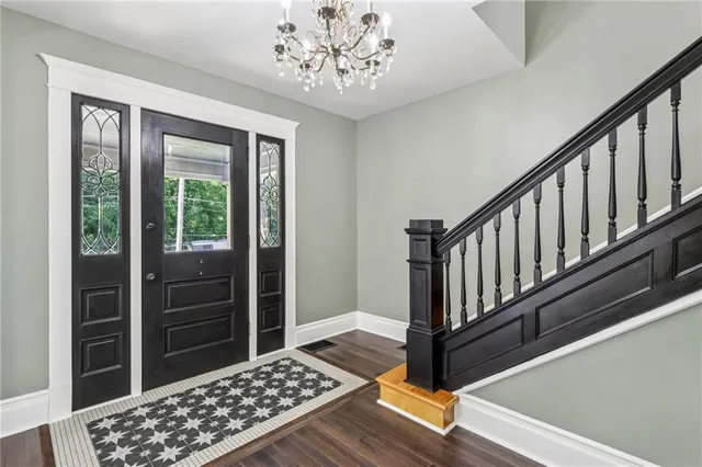a view of a hallway with wooden floor and staircase