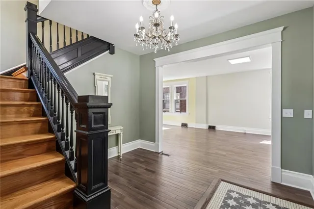 a view of a hallway with wooden floor and staircase