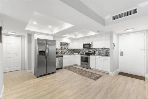a dining room with wooden floor a chandelier a wooden table and chairs
