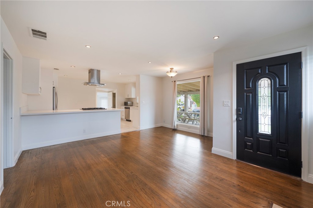 a view of empty room with wooden floor and windows