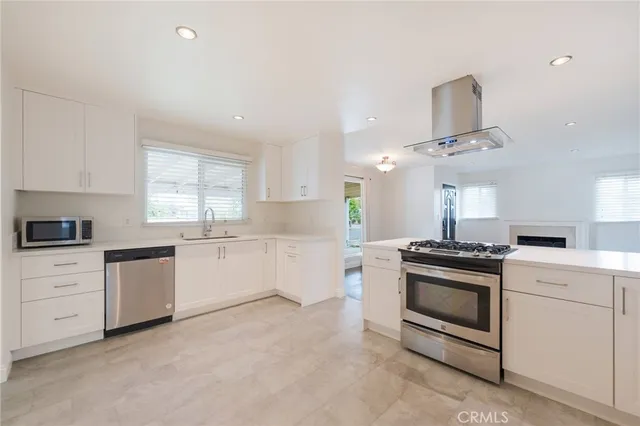 a kitchen with granite countertop white cabinets and white appliances