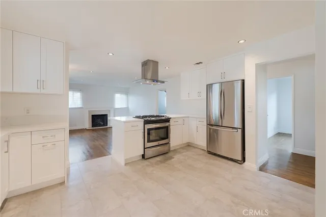 a kitchen with a refrigerator a stove and white cabinets