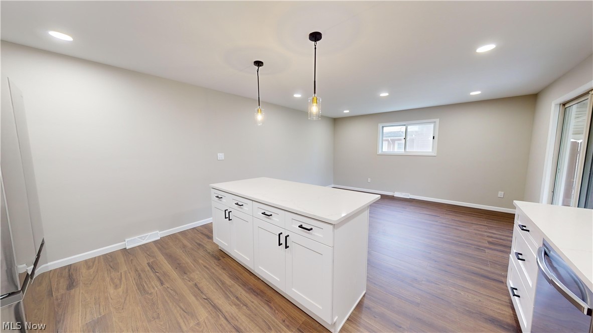 1224 Cordova Road Mayfield Heights, OH 44124 - Photo 10 of 29 Kitchen featuring white cabinets, pendant lighting, a center island, and wood-type flooring