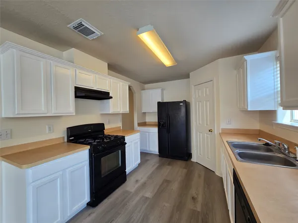 a kitchen with a refrigerator and a stove top oven
