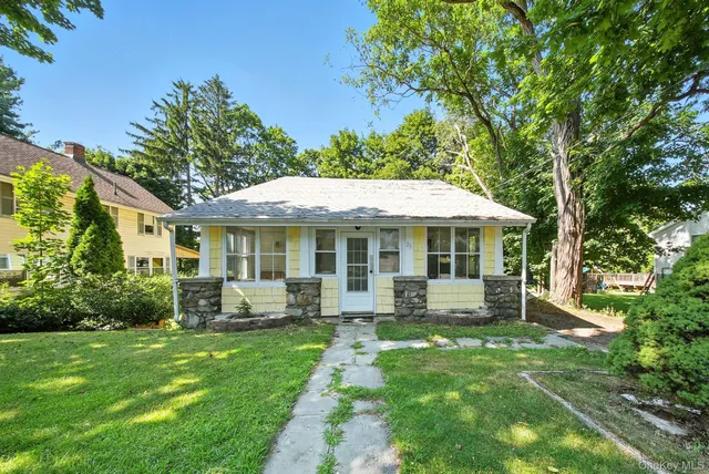 a front view of a house with a yard table and chairs