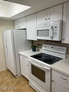 a kitchen with white cabinets white stainless steel appliances and sink
