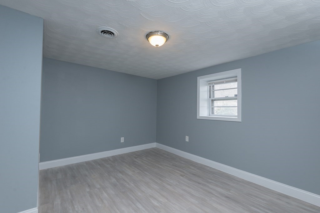 299 Center Street Randolph, MA 02368 - Photo 24 of 32 a view of an empty room with wooden floor and a window