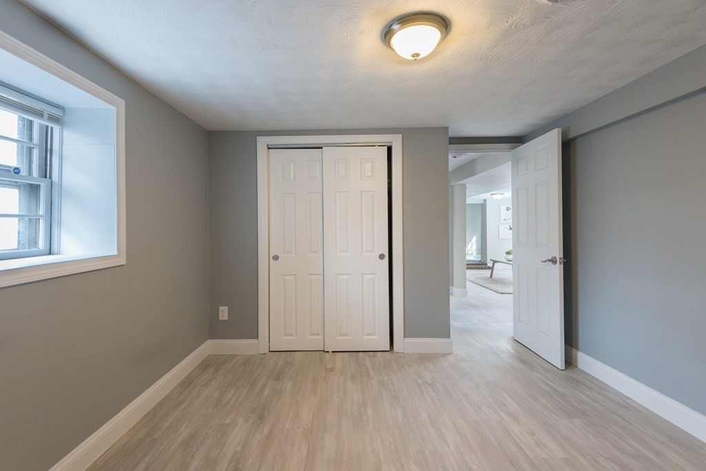 299 Center Street Randolph, MA 02368 - Photo 25 of 32 an empty room with wooden floor and windows