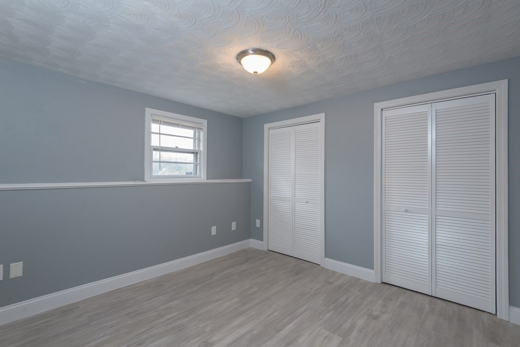 299 Center Street Randolph, MA 02368 - Photo 28 of 32 an empty room with wooden floor and windows