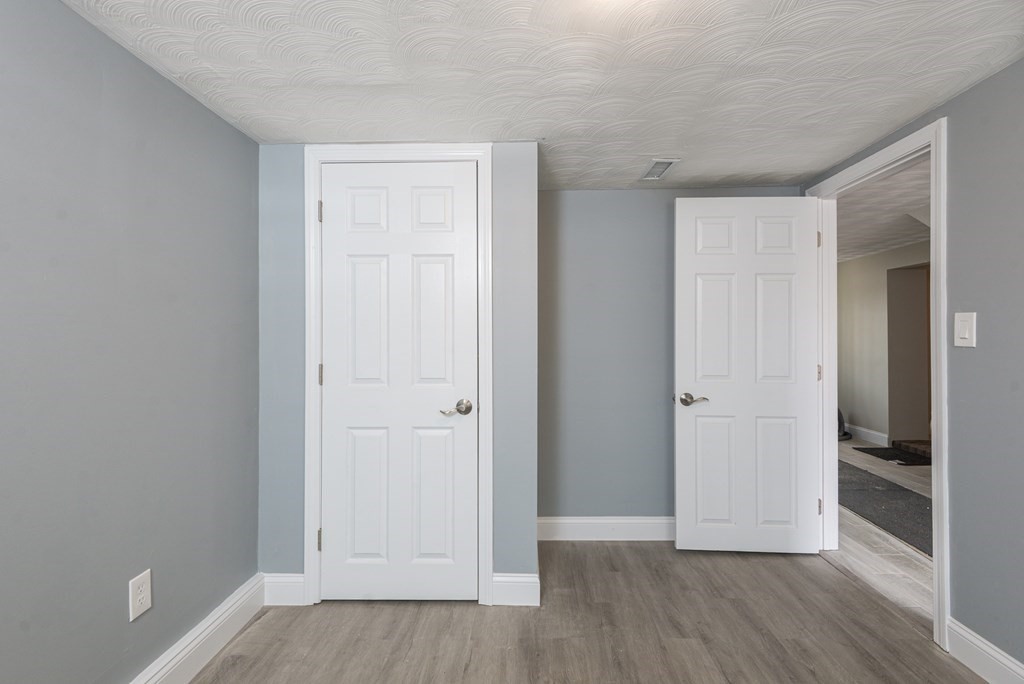 299 Center Street Randolph, MA 02368 - Photo 30 of 32 a view of an empty room with wooden floor and a bathroom