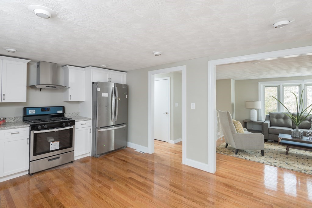 299 Center Street Randolph, MA 02368 - Photo 8 of 32 a kitchen with stainless steel appliances granite countertop a refrigerator stove and sink