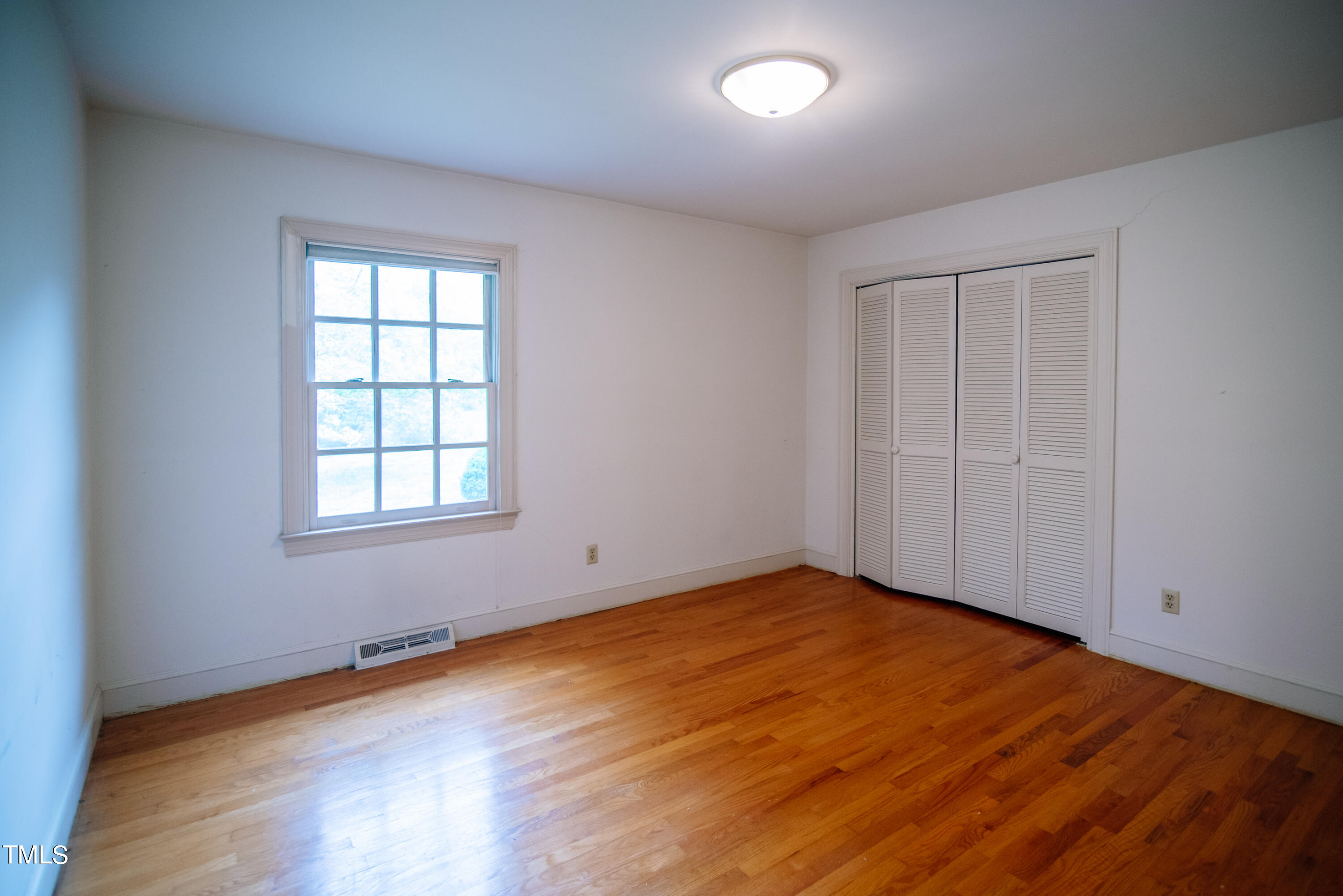 6700 Valley Lake Drive Raleigh, NC 27612 - Photo 14 of 23 an empty room with wooden floor and windows