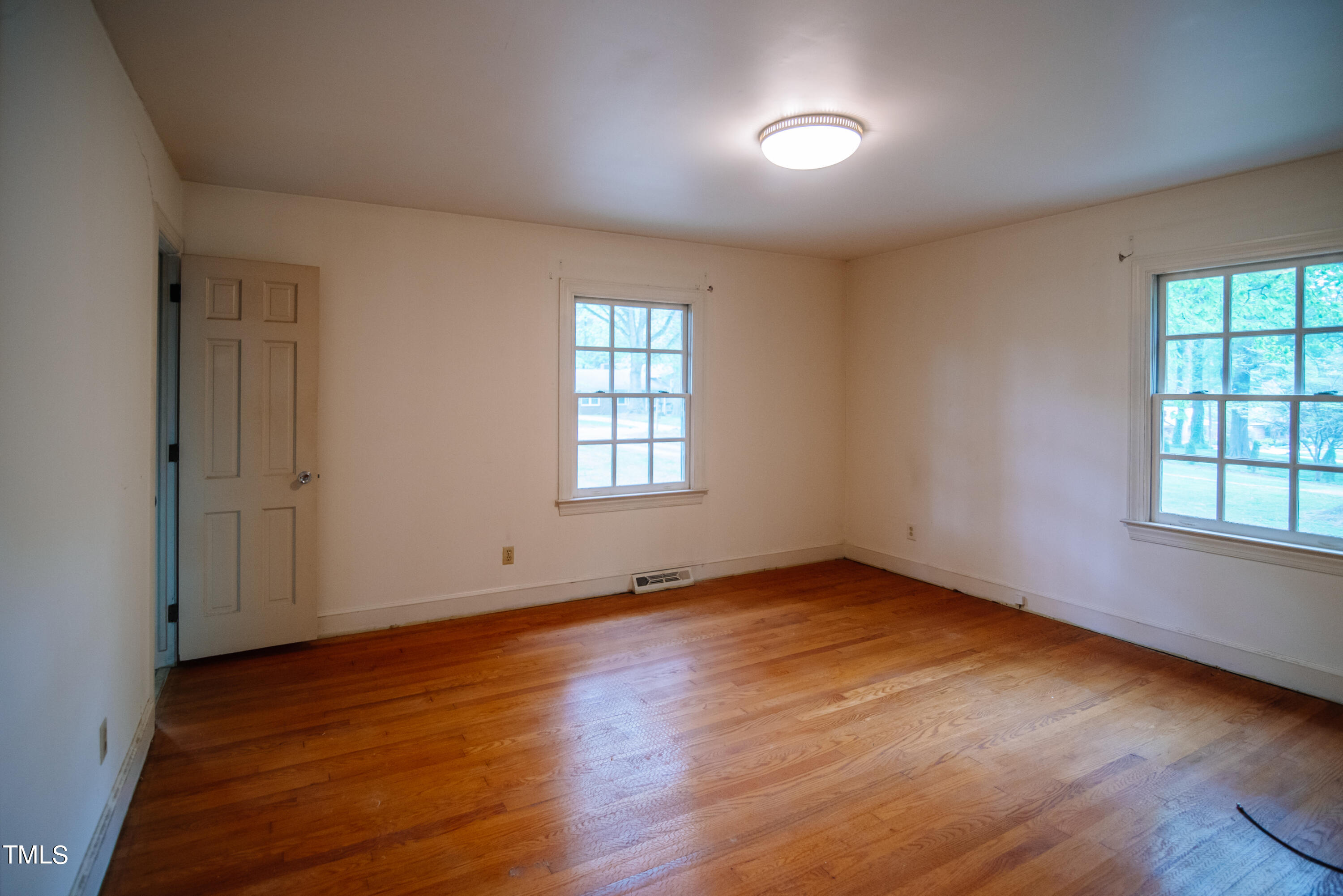 6700 Valley Lake Drive Raleigh, NC 27612 - Photo 15 of 23 an empty room with wooden floor and windows