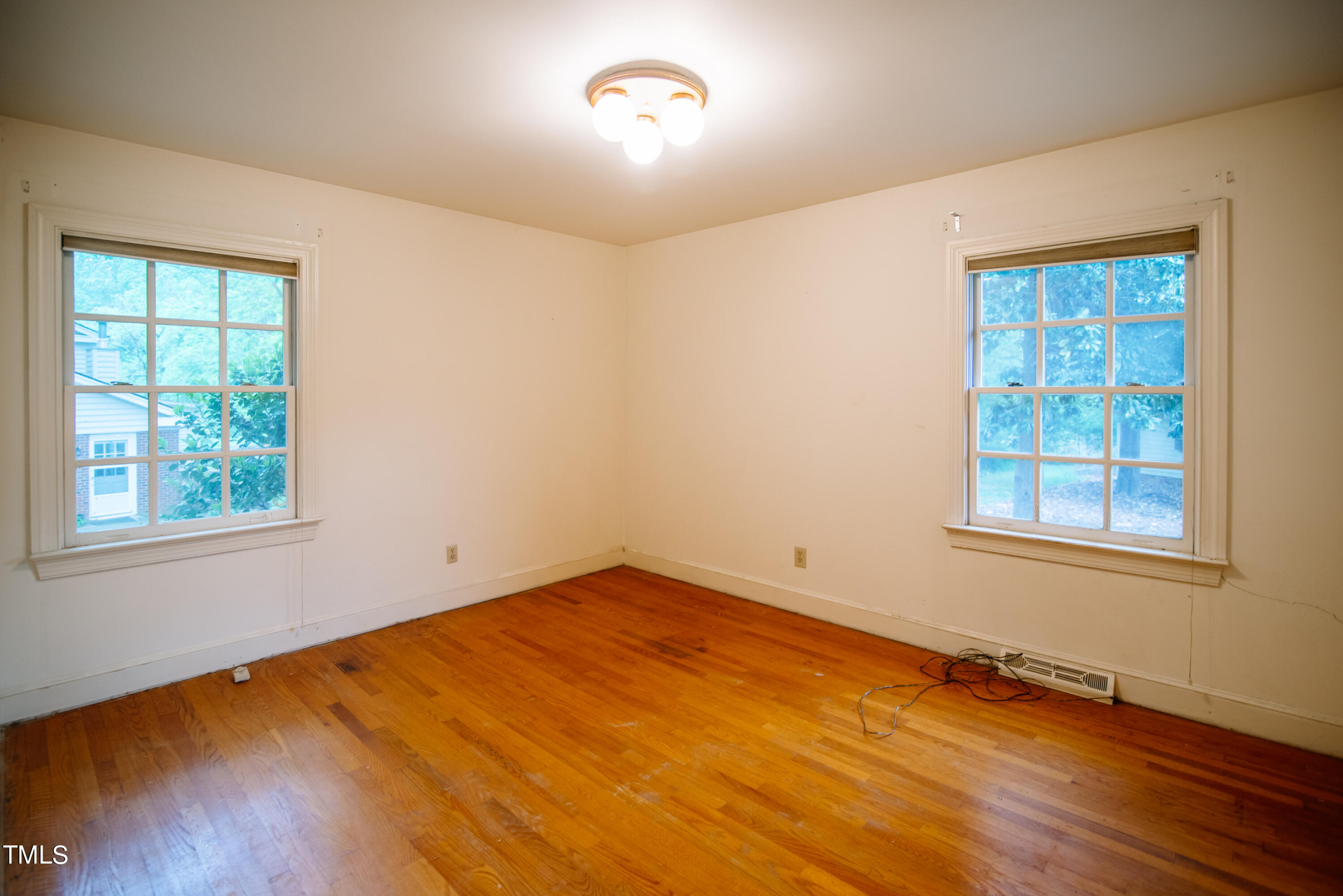 6700 Valley Lake Drive Raleigh, NC 27612 - Photo 17 of 23 an empty room with wooden floor and windows