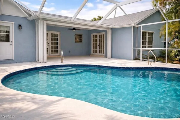 a view of a swimming pool with a patio and a yard