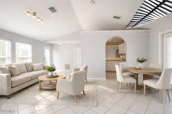 a living room with furniture a table and a potted plant