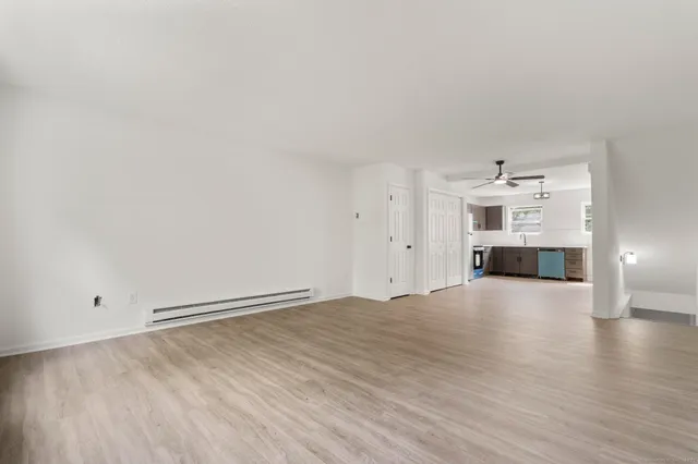 a view of empty room with wooden floor