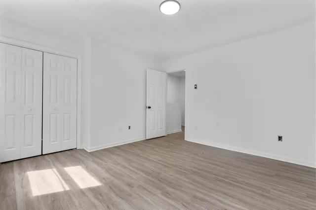 a view of an empty room with wooden floor